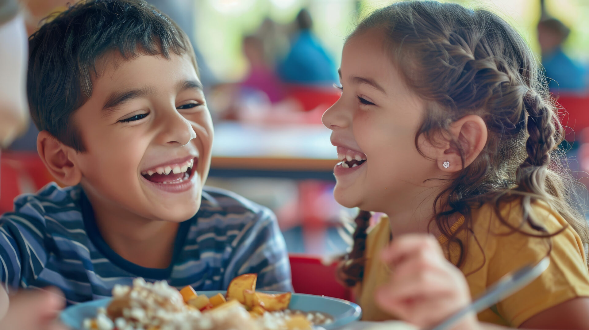 Two european elementary school students joyfully sharing a meal together, their faces beaming with happiness and laughter